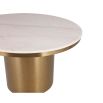 Round dining table with beautiful brushed brass finish and clean white marble top