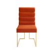 A luxury dining chair by Jonathan Adler with a polished brass base and 70s style red ribbed design