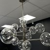 A statement chandelier from Eichholtz with an asymmetrical design, spherical lights and polished nickel finish