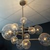 A statement chandelier from Eichholtz with an asymmetrical design, spherical lights and polished nickel finish