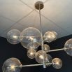 A statement chandelier from Eichholtz with an asymmetrical design, spherical lights and polished nickel finish