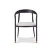 rounded black minimalist dining chair with brass caps on the feet and boucle seat