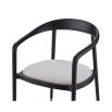 rounded black minimalist dining chair with brass caps on the feet and boucle seat