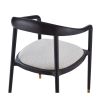 rounded black minimalist dining chair with brass caps on the feet and boucle seat