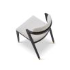 Boucle upholstered dining chair with slanted black legs and brass caps on the feet