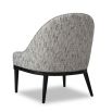 Grey chair with rounded backrest that melts into sloped armrests