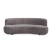 A sumptuous sofa by Liang & Eimil with a curved design and luxury grey velvet upholstery