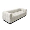 A contemporary sofa with a boucle upholstery and deep channel stitching design