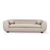 A stylish sofa with a curved design, ball scatter cushions and beige upholstery