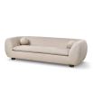 A stylish sofa with a curved design, ball scatter cushions and beige upholstery