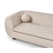 A stylish sofa with a curved design, ball scatter cushions and beige upholstery