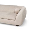 A stylish sofa with a curved design, ball scatter cushions and beige upholstery