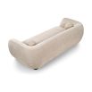 A stylish sofa with a curved design, ball scatter cushions and beige upholstery