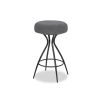 Grey upholstered round seated counter stool with boldly splayed open hourglass base with gentle tapering.