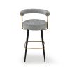 Chic upholstered bar stool with black legs and brass accents