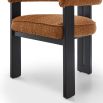 Orange boucle dining chair with three black legs