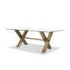 Artisan-crafted dining table with brass legs topped with an expanse of toughened clear glass