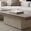 A contemporary coffee table by Caracole with a modern design, clean lines and a travertine stone top