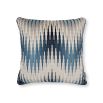 A cushion with a velvet chevron pattern in blue and cream hues.