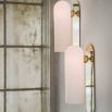 Contemporary solid brass wall lamp in a polished nickel finish with a long translucent glass lampshade