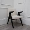 A classic shaped dining chair with contrasting black legs and white boucle upholstery