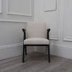 A classic shaped dining chair with contrasting black legs and white boucle upholstery