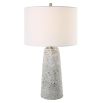 This tapered ceramic lamp has a distressed off-white finish, brushed nickel accents, and a white linen shade, adding timeless elegance to any space.